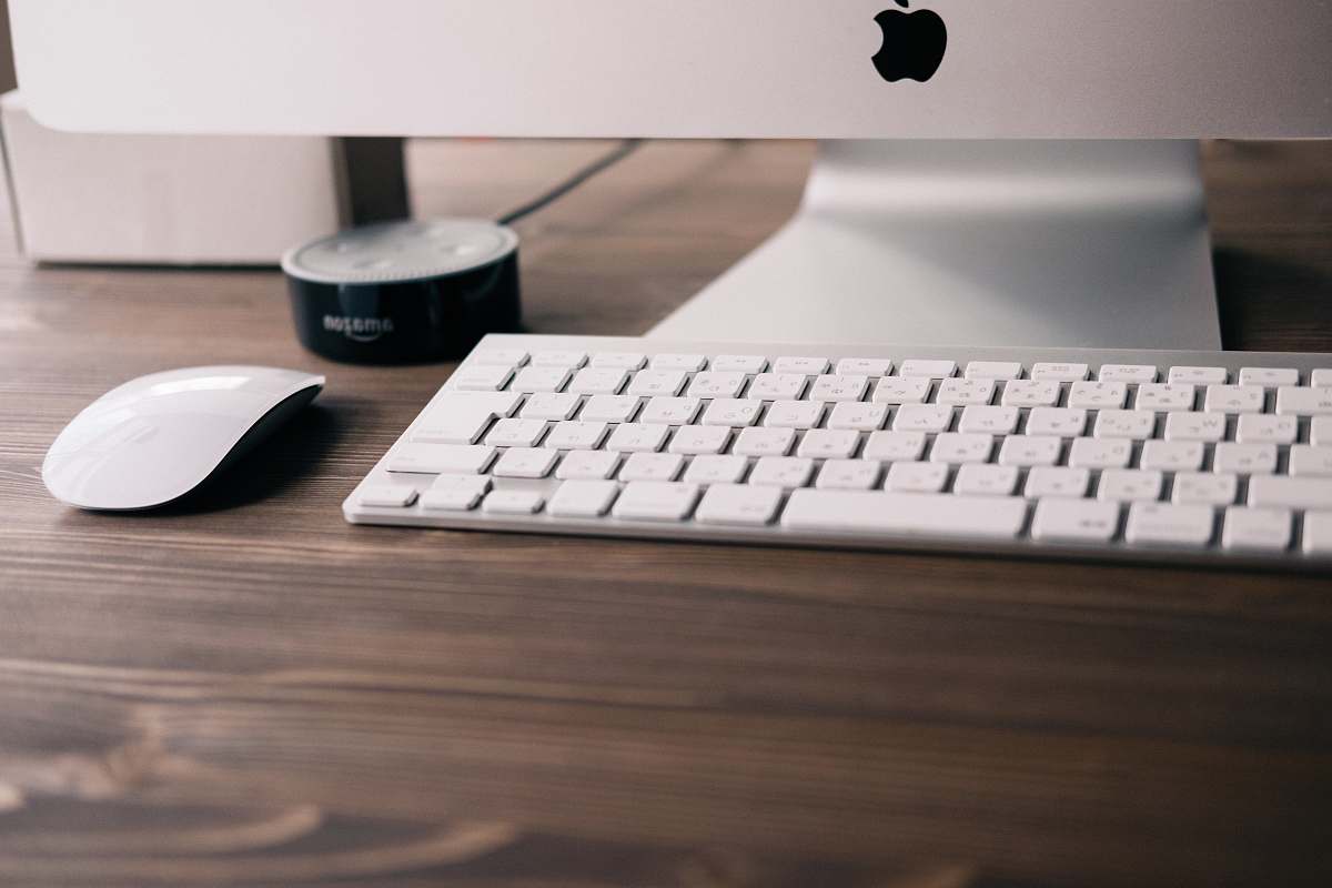 computer keyboard selective focus photography if silver iMac, Apple wireless keyboard, Magic Mouse, and black Amazon Echo Dot 2nd generation at table mouse